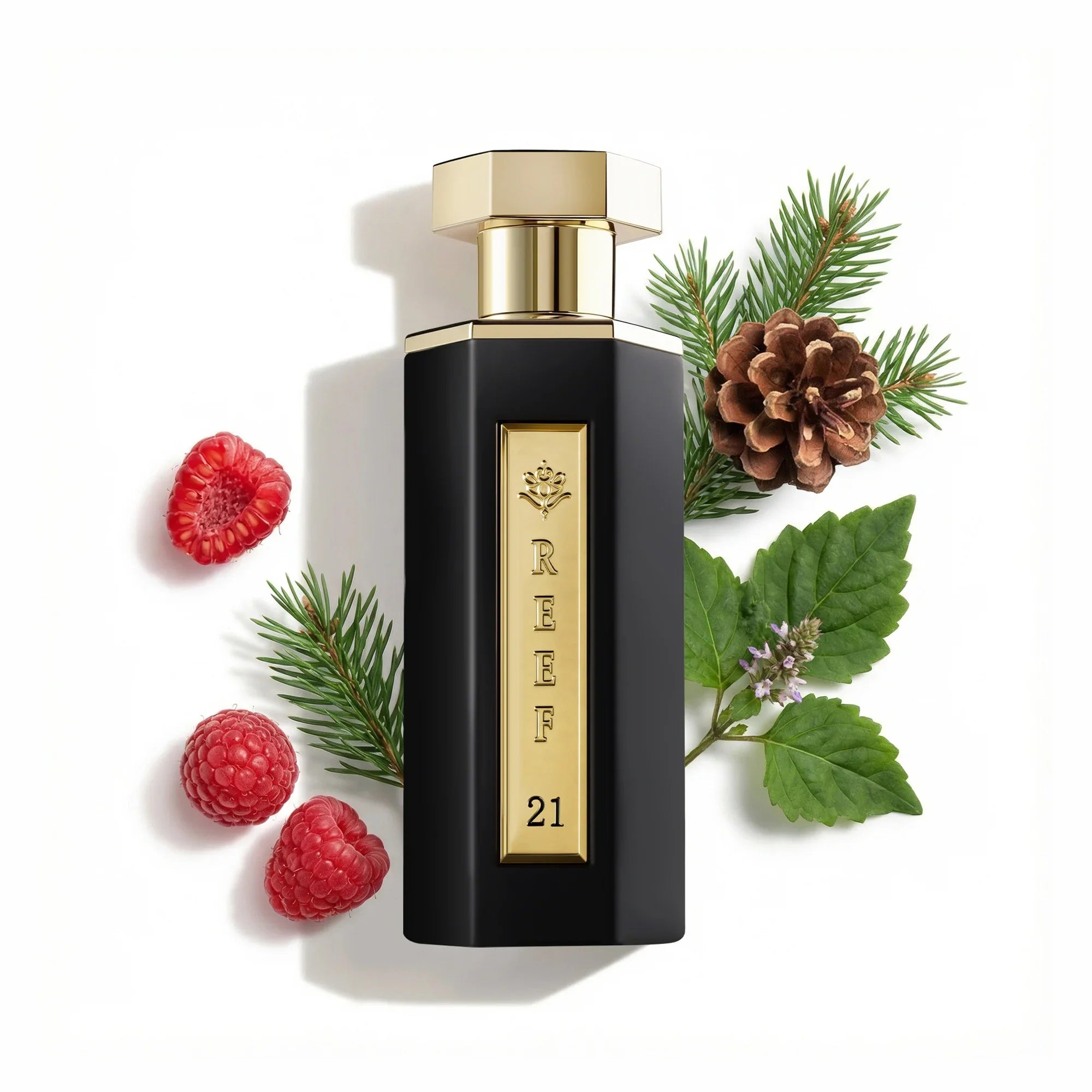 Reef - 21 Eau De Parfum 100ml bottle with gold cap and black body, surrounded by raspberries, pine cones, and leaves on a white background
