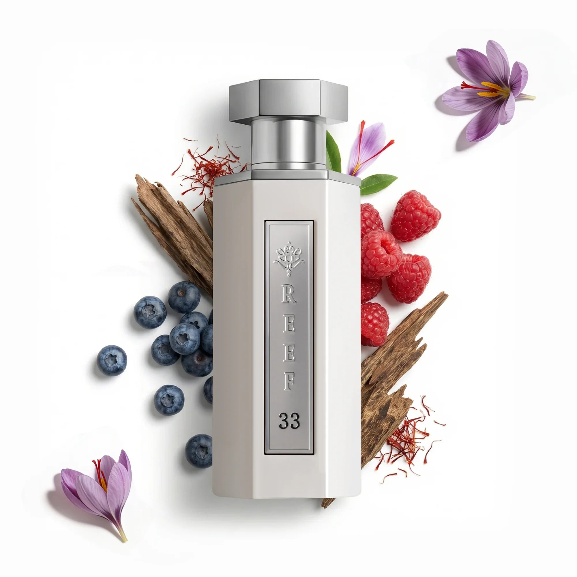 Perfume bottle labeled 'Reef - 33 White 100ml' surrounded by berries, flowers, and spices on a white background