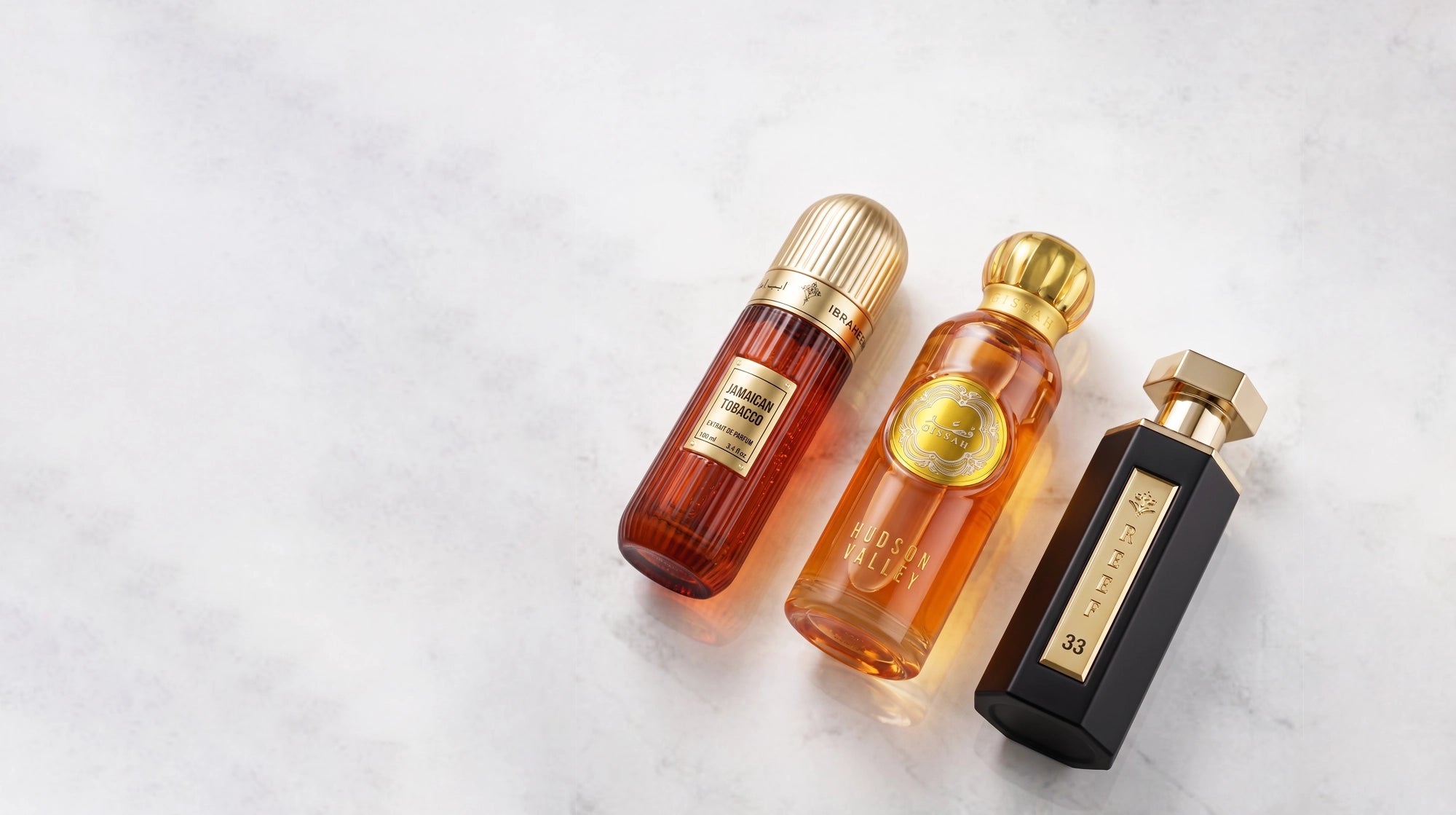 Reef & Ibraq & Gissah perfumes. Three perfume bottles of different sizes on a light gray background