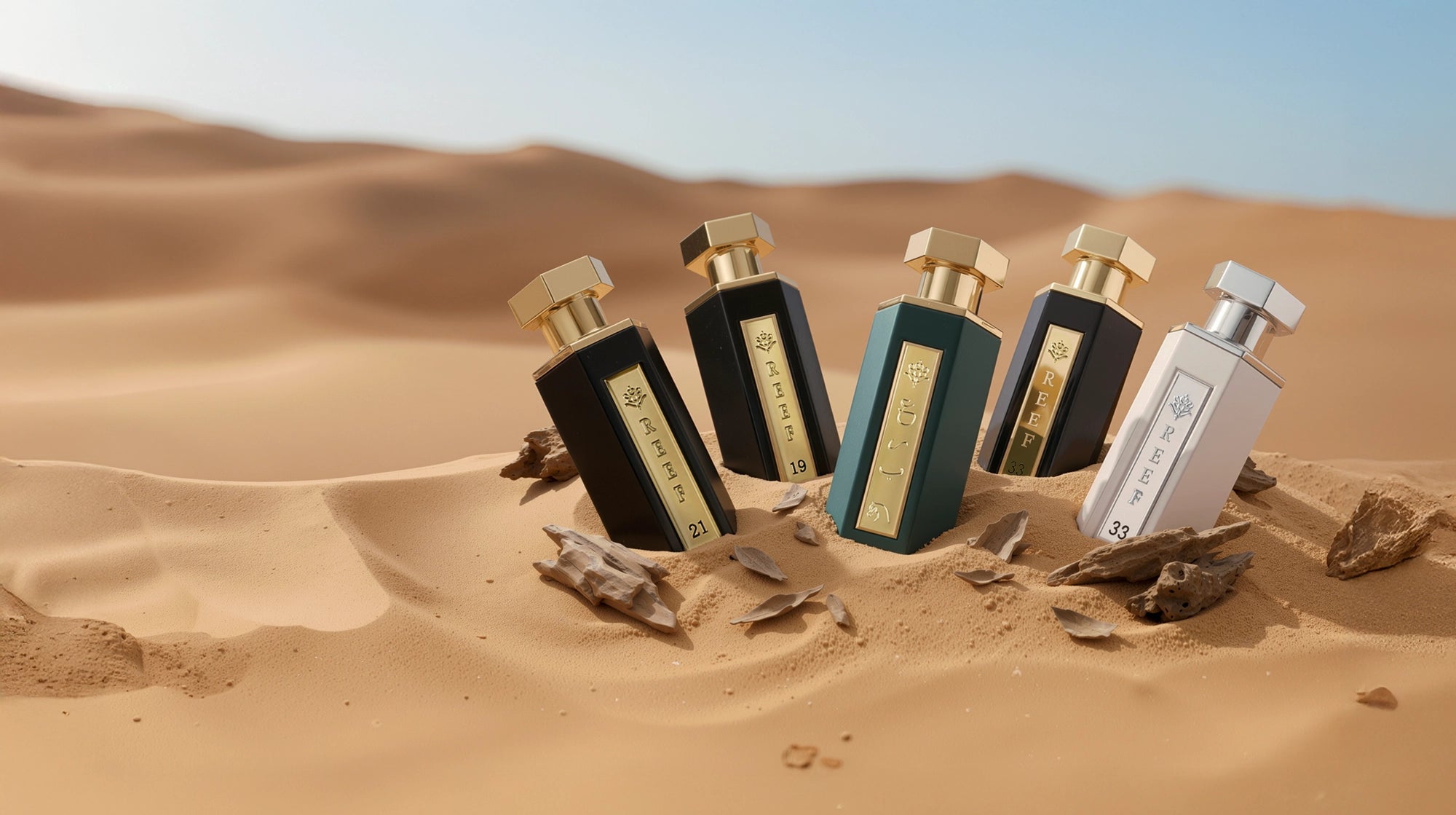 Five Reef perfume bottles in a desert setting